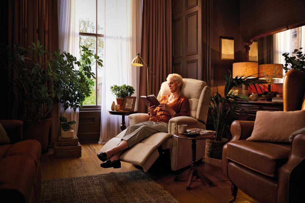 a lady reading a book in a recliner chair